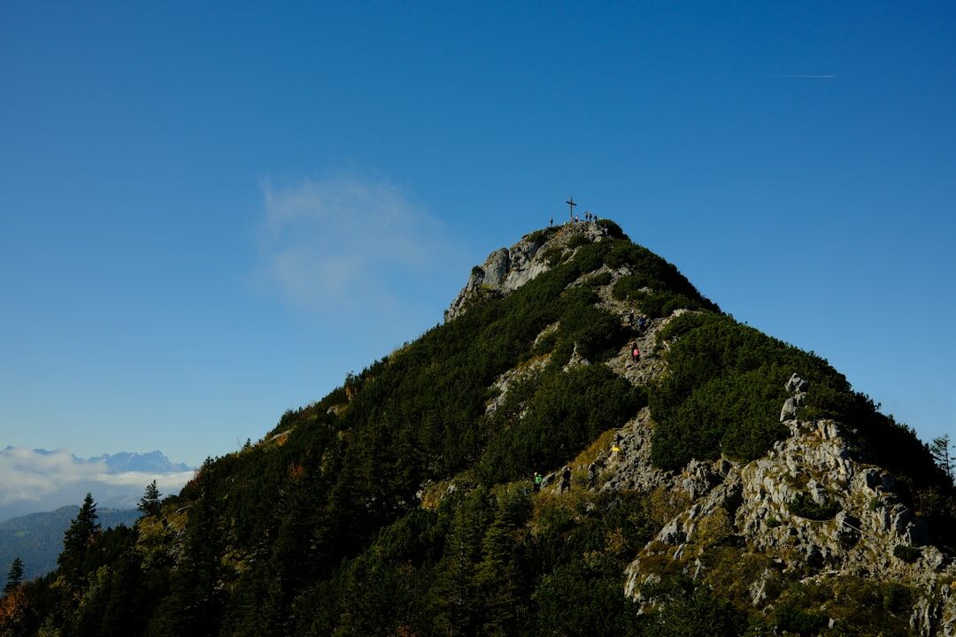 person climbing mountain peak