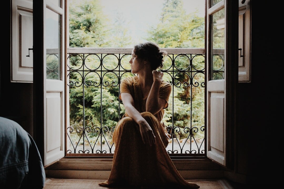 Person sitting calmly by a window practicing mindfulness